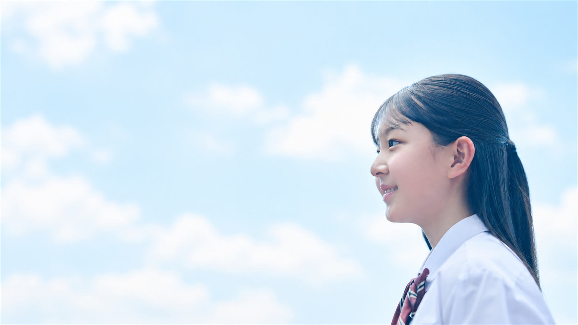 青空を見上げ、新しい一歩を踏み出す中学生